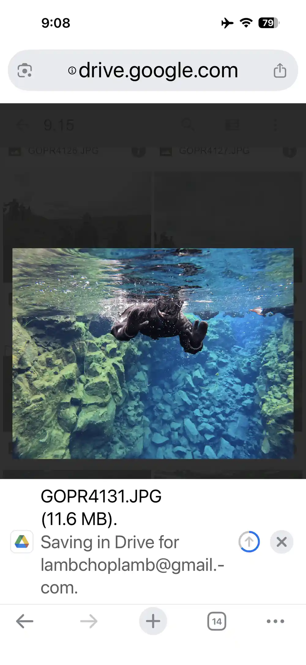 Diver swimming through narrow underwater canyon between rocks
