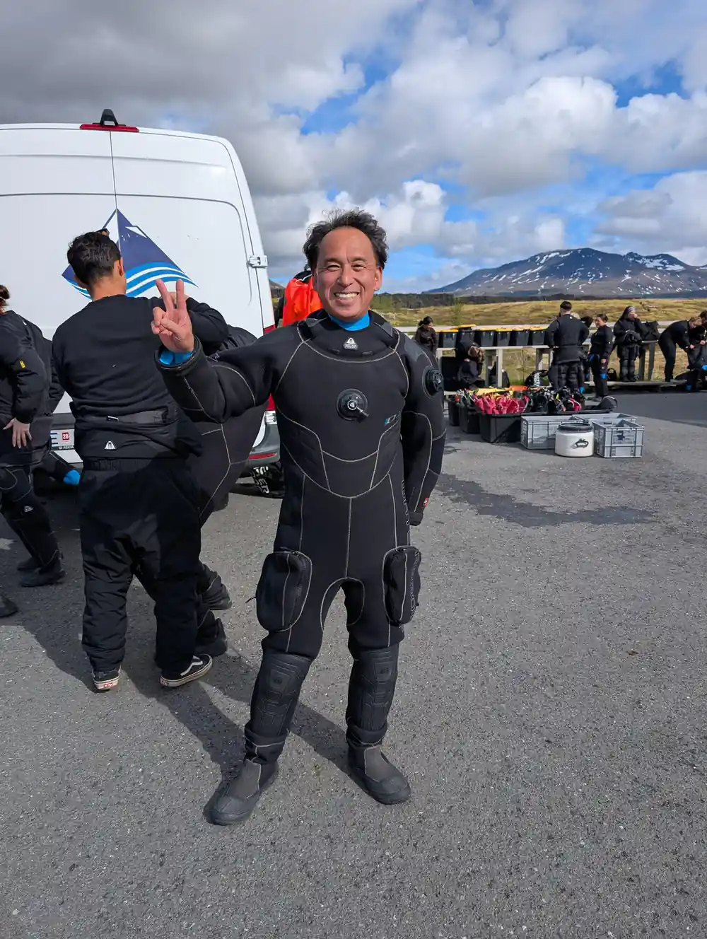 Man in wetsuit standing after diving near vehicle