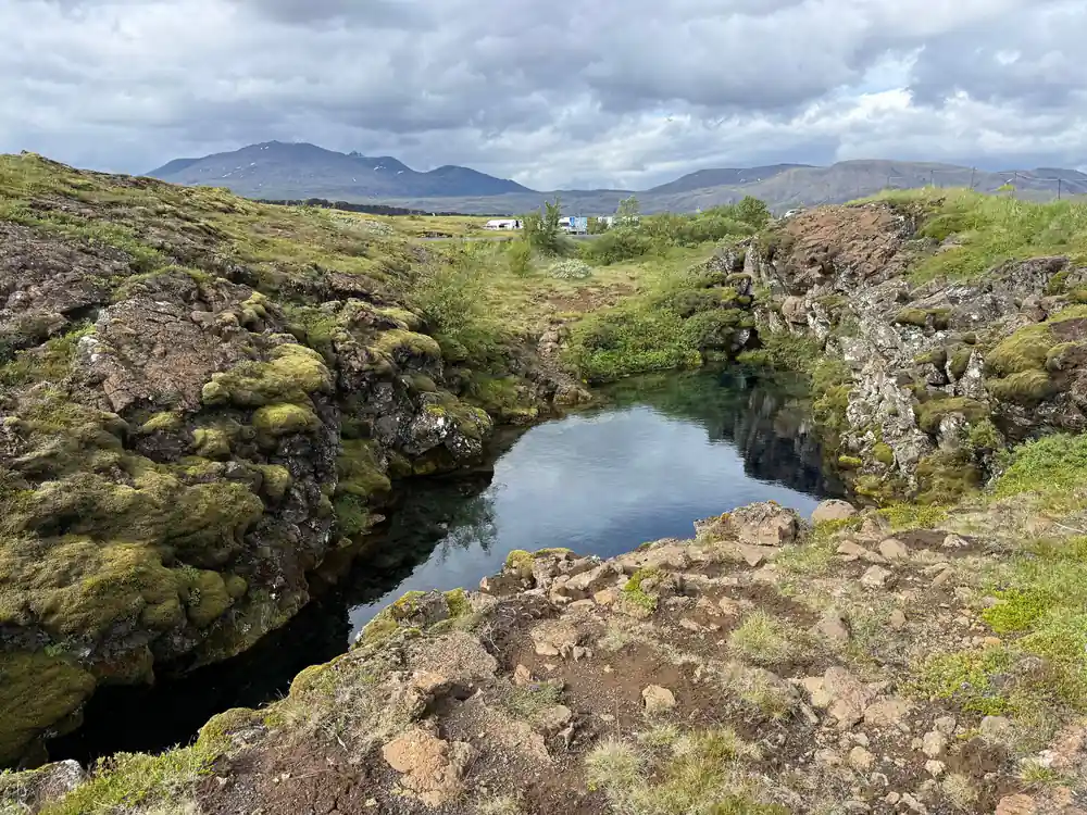 Moss-covered lava rocks surrounding pool of water