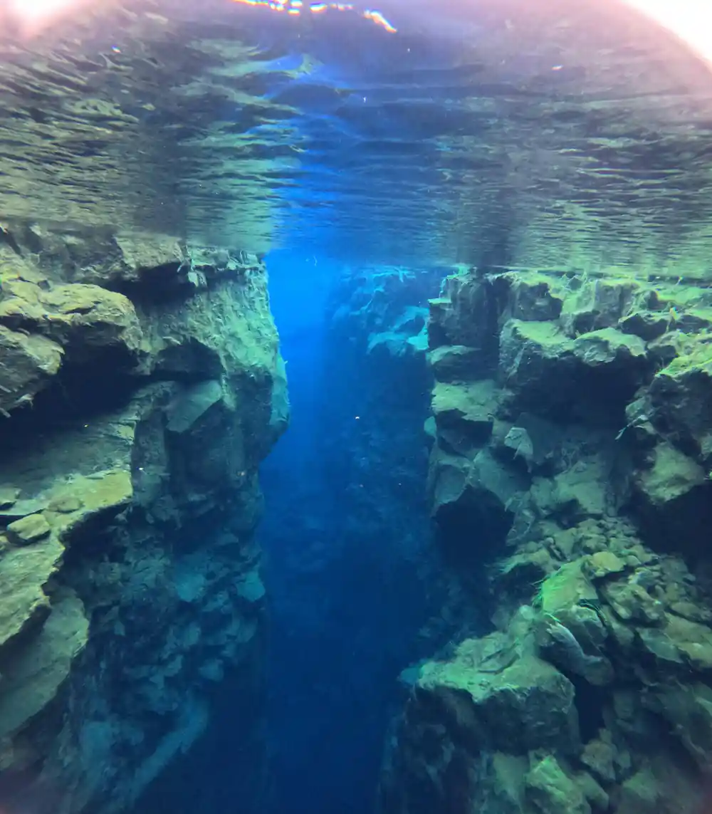 Snorkelers in narrow canyon between tall rock walls