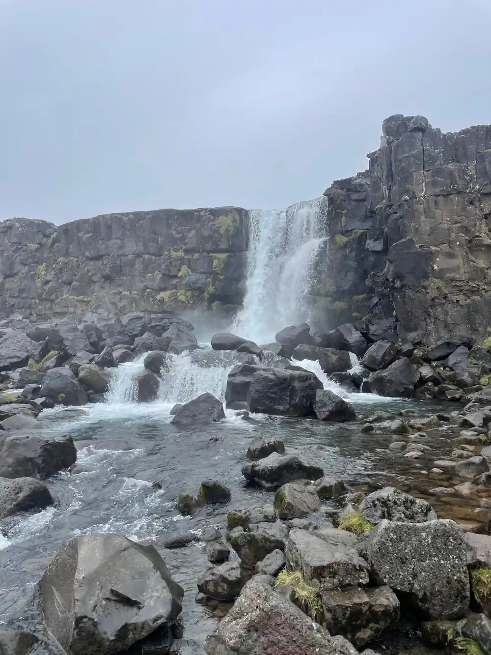 Waterfall cascading over dark rocky cliff face